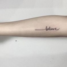 a woman's arm with the word believe written on it and an arrow tattoo