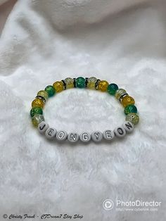 This elastic bead bracelet was made by hand & inspired by Jeongyeon! It features glass beads, green rhinestone spacer beads, & acrylic alphabet beads. 8mm Glass Beads: ~ Clear/yellow crackle ~ Green/yellow crackle ~ Yellow crackle Please note: ~ I use quality elastic when making the bracelets, but the elastic can still break if overstretched. ~ Sizing Guide: Refer to posted image for more information on 2 sizes available Green Name Bracelet With Letter Beads, Trendy Green Letter Beads, Green Beaded Bracelets With Letter And Round Beads, Trendy Green Crystal Round Beads Bracelet, Trendy Green Crystal Bracelet With Round Beads, Casual Green Stretch Bracelet With Letter Beads, Green Letter Beads, Elastic Bead Bracelet, Alphabet Beads