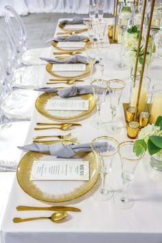 the table is set with gold plates and silverware