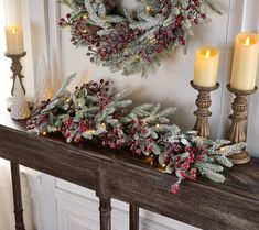 a mantle with candles and wreaths on it