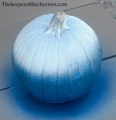 a blue pumpkin sitting on top of a sidewalk