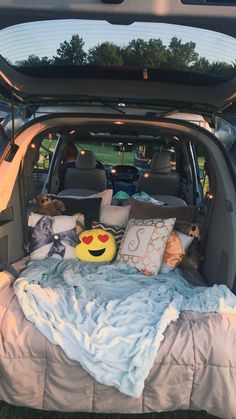 the back end of a car with stuffed animals in it's trunk and bed