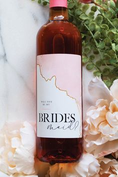 a bottle of wine sitting on top of a table next to white and pink flowers