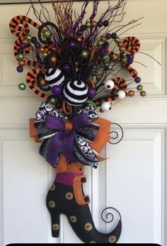 a door hanger decorated with halloween decorations and an orange, black and white cat