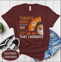 Funny Turkey tee , Turkey Gravy Beans And Rolls Let Me See That Casserole T-shirt Funny thanksgiving shirts for women and Men : - Classic unisex jersey short sleeve tee made from soft cotton.   - Quality print ensures durability and attractiveness. - Features ribbed knit collars for shaping and tapered shoulders for better fit. - Dual side seams maintain garment shape over time. - Made from 100% lightweight Airlume combed and ring-spun cotton (4.2 oz/yd²). - Ideal for layering, breathable, suita Thanksgiving Graphic Print Crew Neck T-shirt, Fall Graphic Tee With Funny Text, Thanksgiving Letter Print Crew Neck Top, Funny Crew Neck T-shirt For Fall, Thanksgiving Shirts For Women, Funny Thanksgiving Shirts, Semi Formal Wear, Funny Turkey, Turkey Gravy