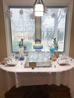 a table is set up in front of a window with snowflakes on it