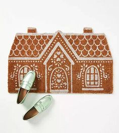 a pair of green shoes sitting on top of a door mat next to a house