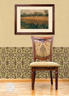 a wooden chair sitting in front of a wall with a painting on it's side