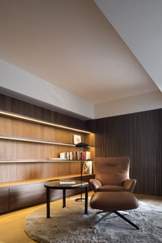 a living room with a chair, table and bookshelf on the wall behind it