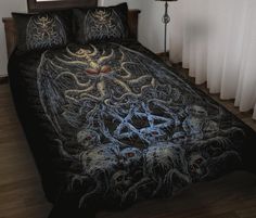 a bed covered in a black bedspread with skulls and demon heads on it