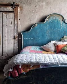 an old bed with colorful pillows and blankets