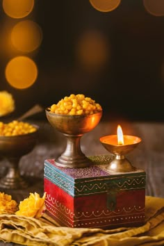 a small bowl filled with food next to a candle