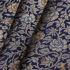 blue and gold brocaded fabric with floral designs on the side, close up