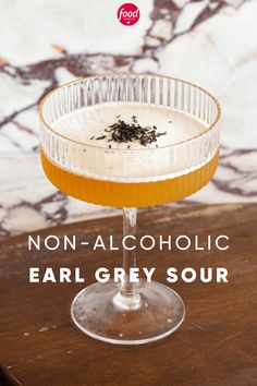 an alcoholic drink in a glass on top of a table with the words non - alcoholic ear grey sour