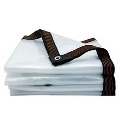 three white sheets with brown straps on them are stacked up against each other and one is folded down