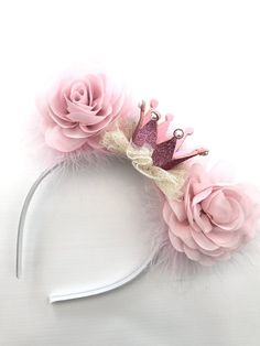 a headband with pink flowers and a crown on it