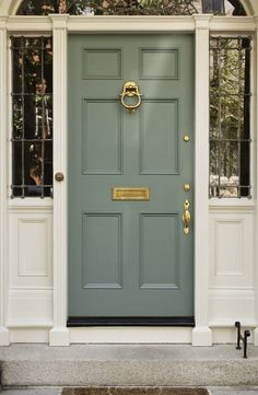 the front door is painted blue and has an arched glass window above it, along with two sidelights on either side