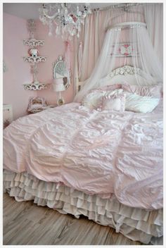 a pink bedroom with a canopy bed, chandelier and white bedspread