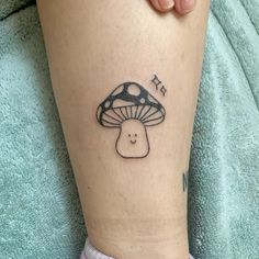 a small mushroom tattoo on the leg