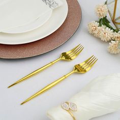 the table is set with goldware and white napkins