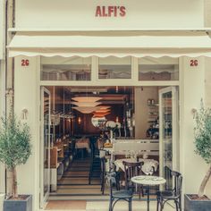 a restaurant with tables and chairs in front of the entrance to it's store