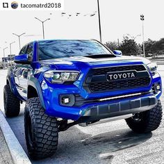 a blue toyota truck is parked on the street