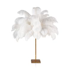 a white feather lamp on a wooden stand