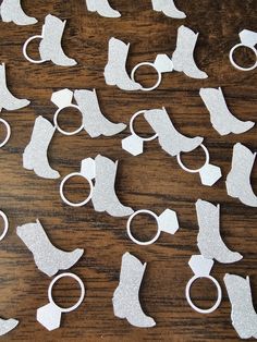 several pairs of handcuffs and boots cut out from white paper on a wooden table top