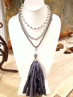 "We all have those close friends that feel like such a \"gift\" to our lives. Their friendship means everything to you! With this Silk Sari Ribbon Tassel Necklace you can express that feeling with something tangible! Made of strips of 100% Silk, it is handcrafted in America, with a fluorescent Czech glass bead, a blackened CZ Bead, a beautifully detailed Silver Fluted Cap, and CZ Rondelles. The length of the tassel is 6 1/2- 7\" including the loop. * this color is a French Blue/Grey Look that's Silver Bohemian Tassel Necklace As Gift, Bohemian Silver Tassel Necklace Gift, Tassel Long Necklace Jewelry For Gifts, Long Tassel Necklace As Gift, Long Tassel Necklace Jewelry For Gift, Long Tassel Necklace For Gifts, Ribbon Tassel, Sari Ribbon, Necklaces Set