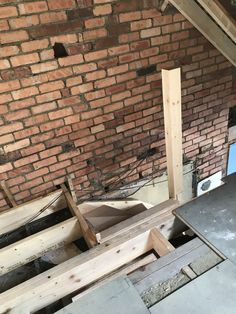 an unfinished room with brick walls and wooden beams