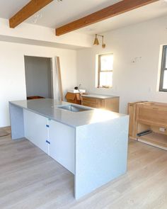 an empty kitchen with wooden floors and white walls