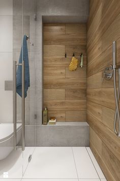 a modern bathroom with wood paneling on the walls and floor, along with a shower head