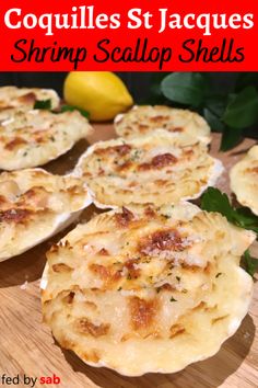 several scallop shells on a cutting board with lemons in the background and text overlay that reads coquilles st jacque shrimp scallop shells