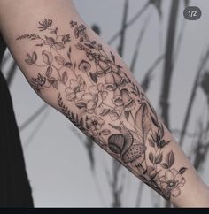 a woman's arm with flowers and birds on it, in black and white