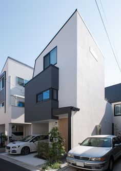 two cars are parked in front of the house