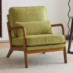 a green chair sitting on top of a white rug