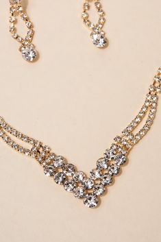 The V-shaped necklace features rhinestone pave and studs, creating a stunning design that catches the light beautifully. The matching earrings complete the look, with the same intricate design as the necklace. Perfect for any occasion, from a night out with friends to a formal event, this set adds a touch of glam to any outfit. SizeLength: 15.5 in (39.37 cm)Ext: 4.5 in (11.43 cm) Quality Made with lightweight metal alloy, and rhinestones. The necklace has an extension so it can be adjusted to yo Glamorous Crystal Jewelry Sets With Sparkling Stones, Glamorous Sparkling Crystal Jewelry Sets, Glamorous Sparkling Diamond White Rhinestone Necklace, Glamorous Diamond White Sparkling Rhinestone Necklace, Glamorous Crystal Jewelry Sets With Rhinestones, Diamond White Rhinestone Jewelry Sets For Party, Night Out With Friends, V Necklace, Pearl Shop