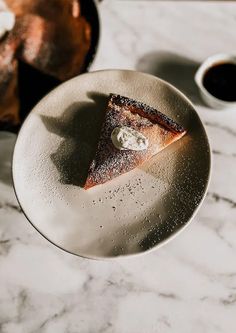 a piece of pie on a plate with coffee