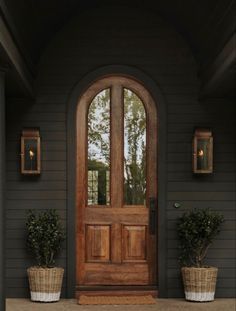 a front door with two planters on either side