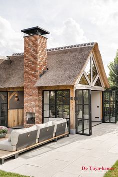 a house with a thatched roof and white couches in front of the patio