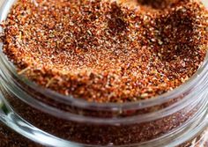 a jar filled with lots of different kinds of seasoning on top of a table