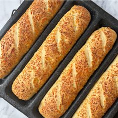 four loaves of bread sitting on top of a baking pan next to each other