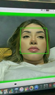 a computer screen with a woman's face in the center and green lines across it