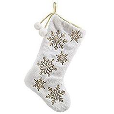 a white christmas stocking with gold snowflakes hanging from it's side