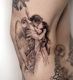 a woman with an angel tattoo on her thigh holding onto a man's back