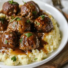 meatballs and gravy on top of mashed potatoes