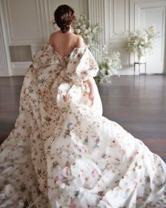 a woman in a white dress is sitting on the floor with her back to the camera