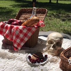 a table topped with two baskets filled with food and a skull sitting on top of it