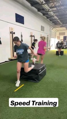 a group of people in a gym with one person jumping on a trampoline