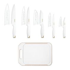 a set of white knives sitting on top of a cutting board